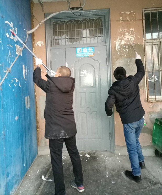 1612254845113516.jpg 图为:物业公司员工清理小广告现场_副本.jpg